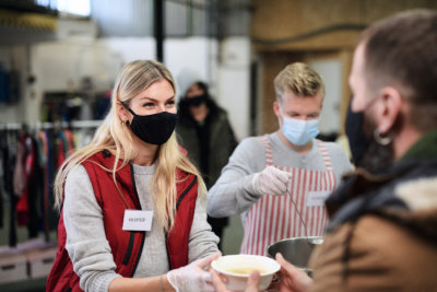 A volunteer giving a bowl of soup