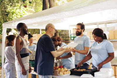 Group of cheerful volunteers giving out free food