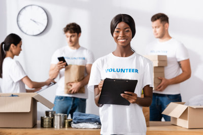 volunteer holding clipboard with her co-volunteers behind