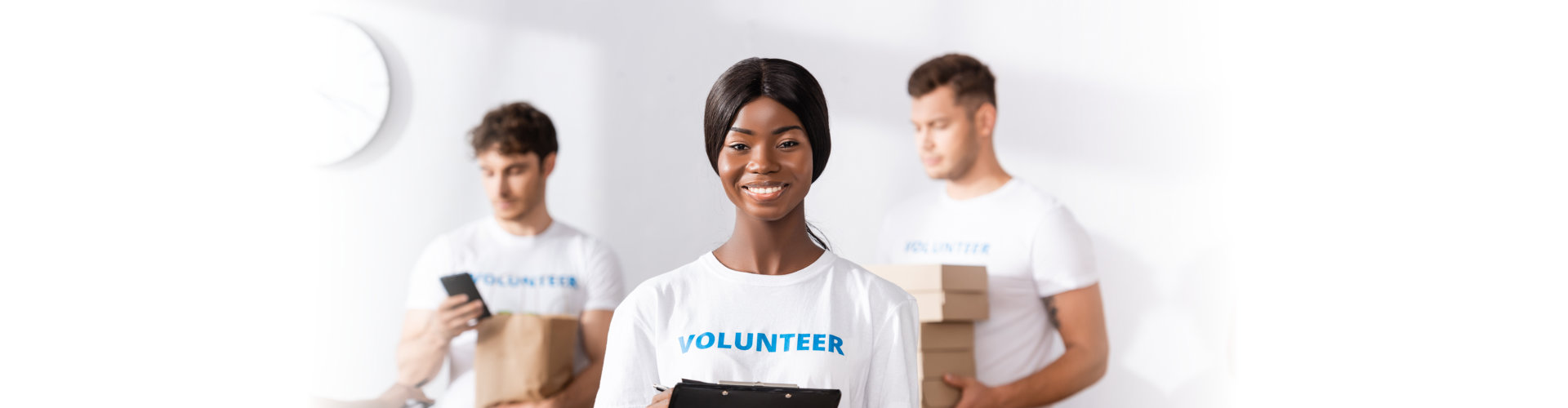 volunteer holding clipboard with her co-volunteers behind